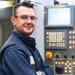 image of technician standing in front of cnc lathe turret